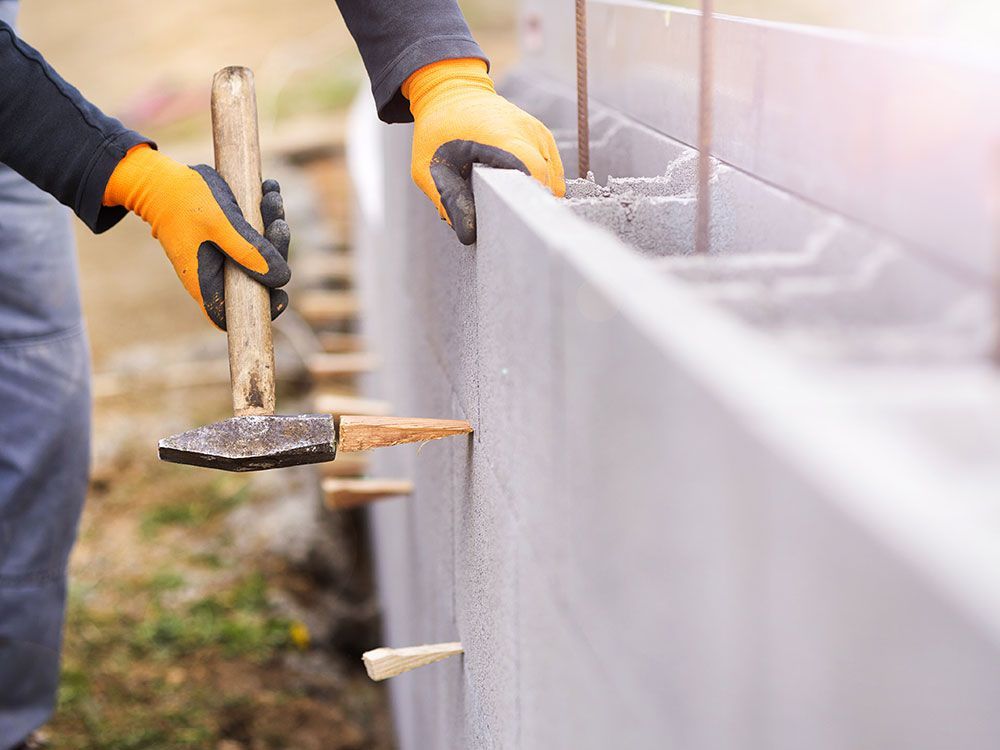 a person wearing orange gloves is working on a concrete