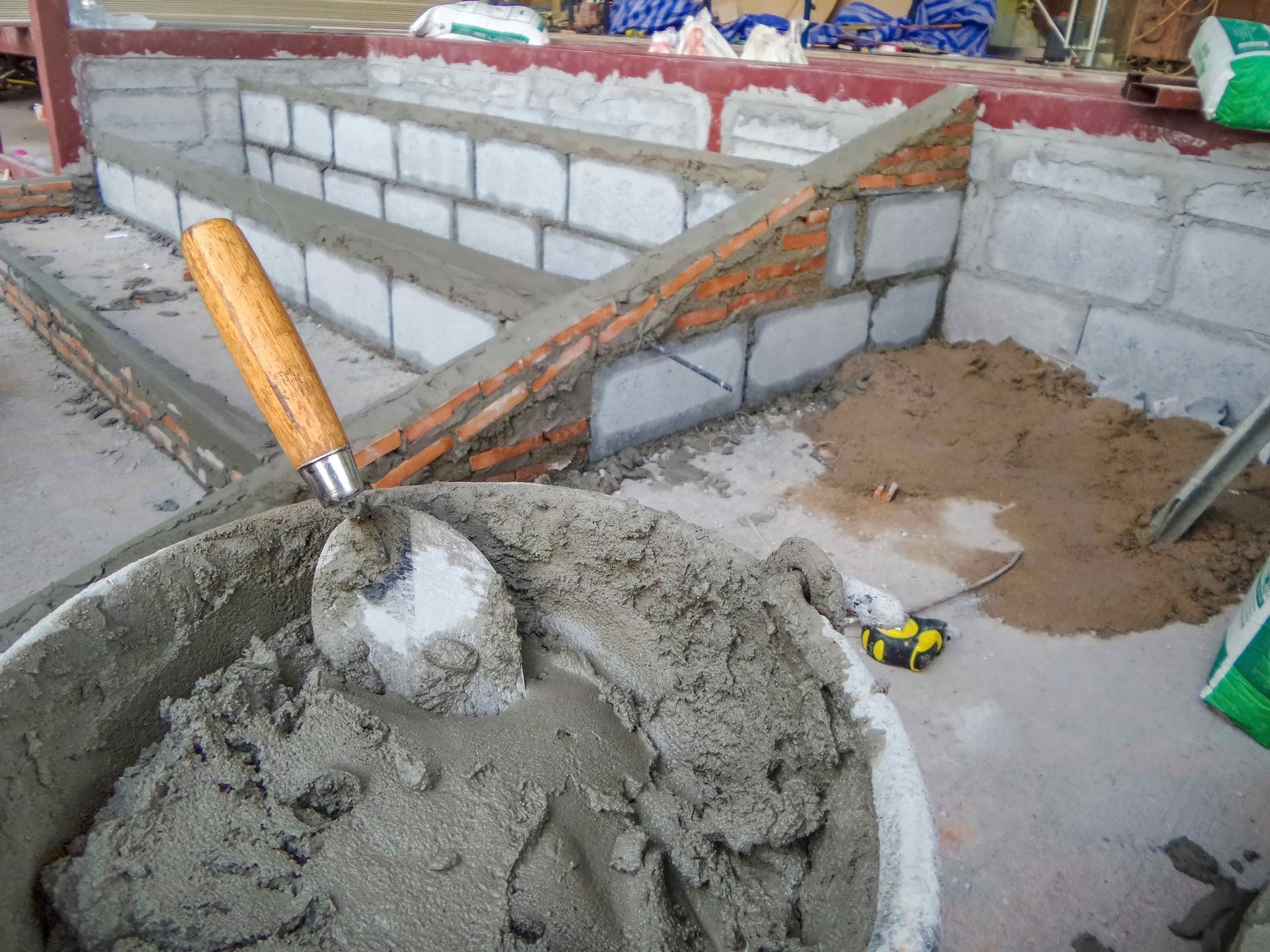 a bucket of concrete with a trowel in it