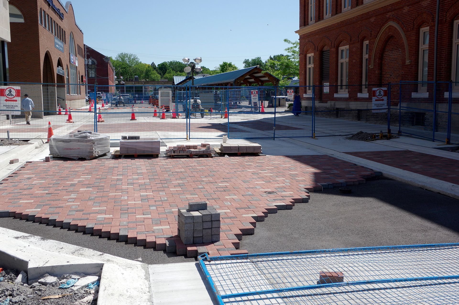 A brick walkway is being built in front of a brick building