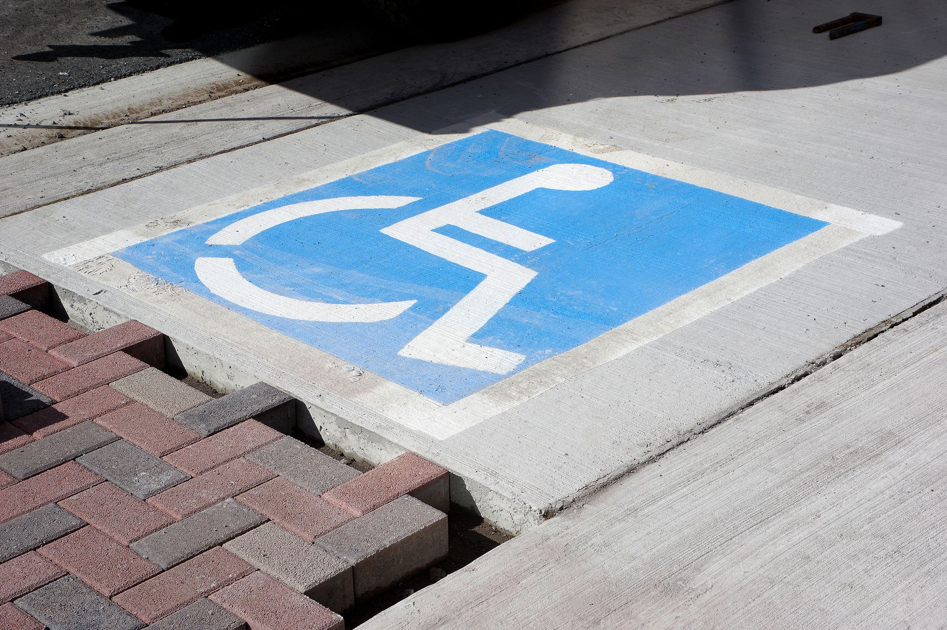 A handicapped sign is painted on the sidewalk