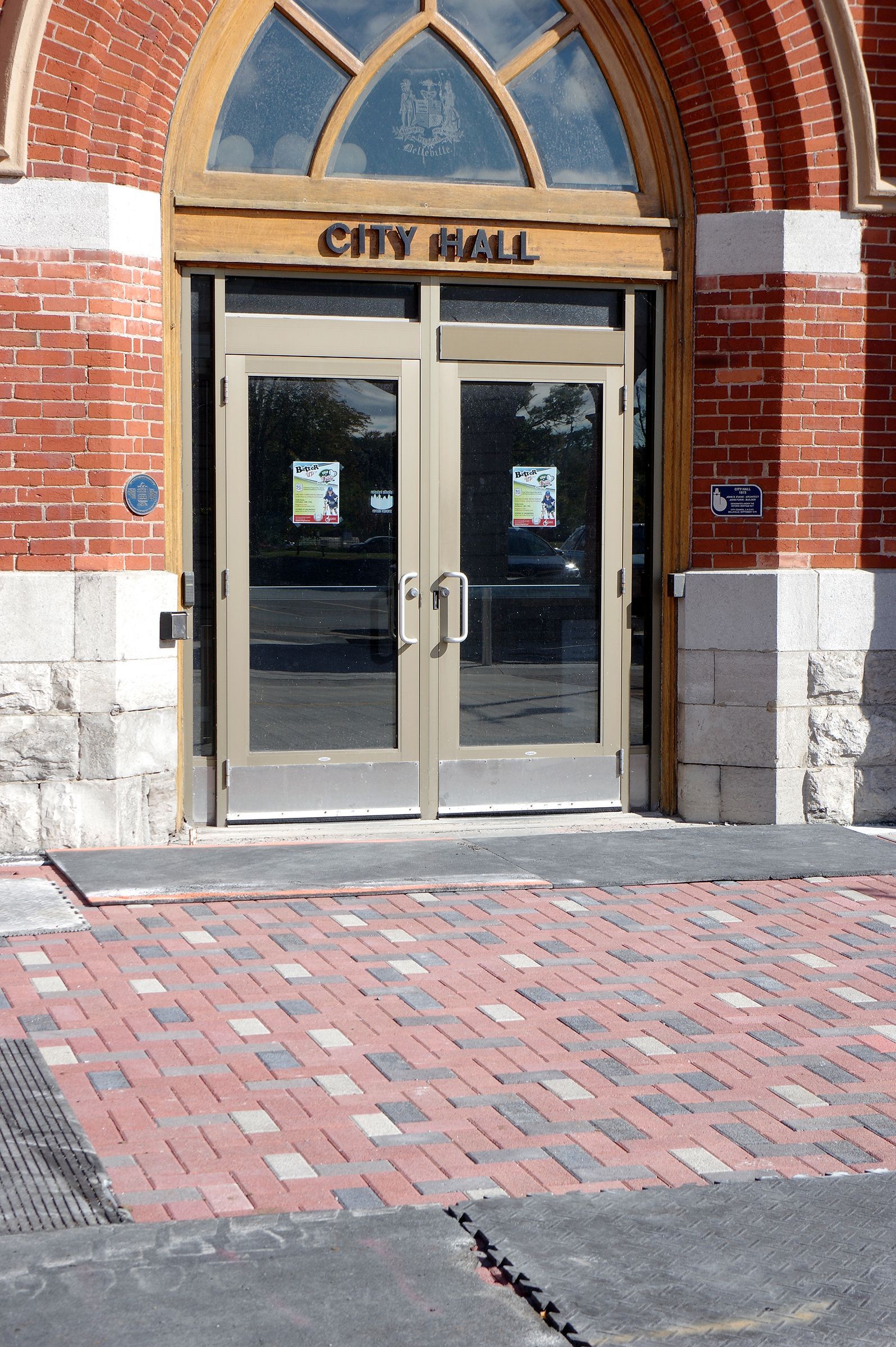 A brick building with a city hall sign above the door
