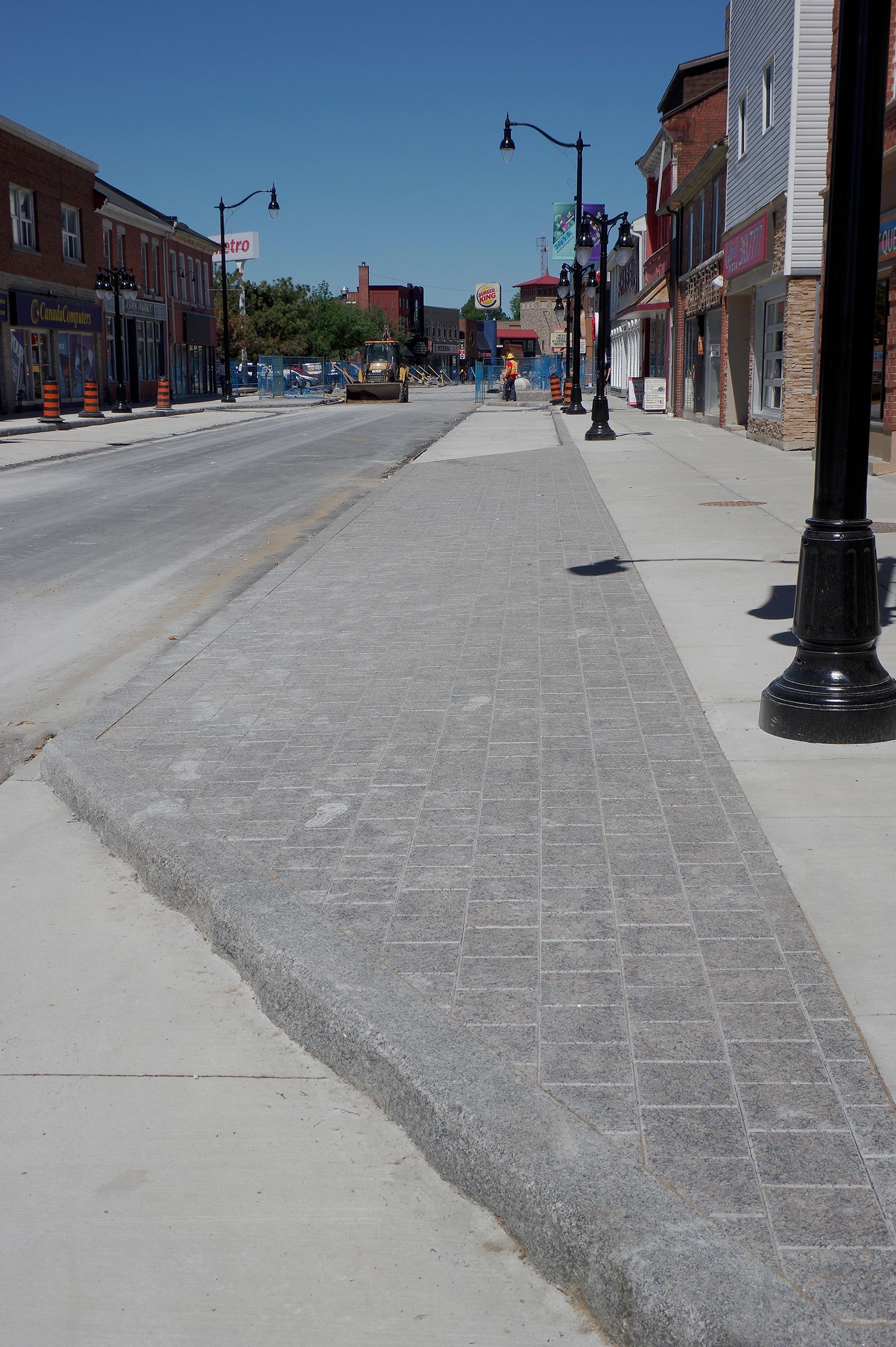 A brick sidewalk along a street in a small town