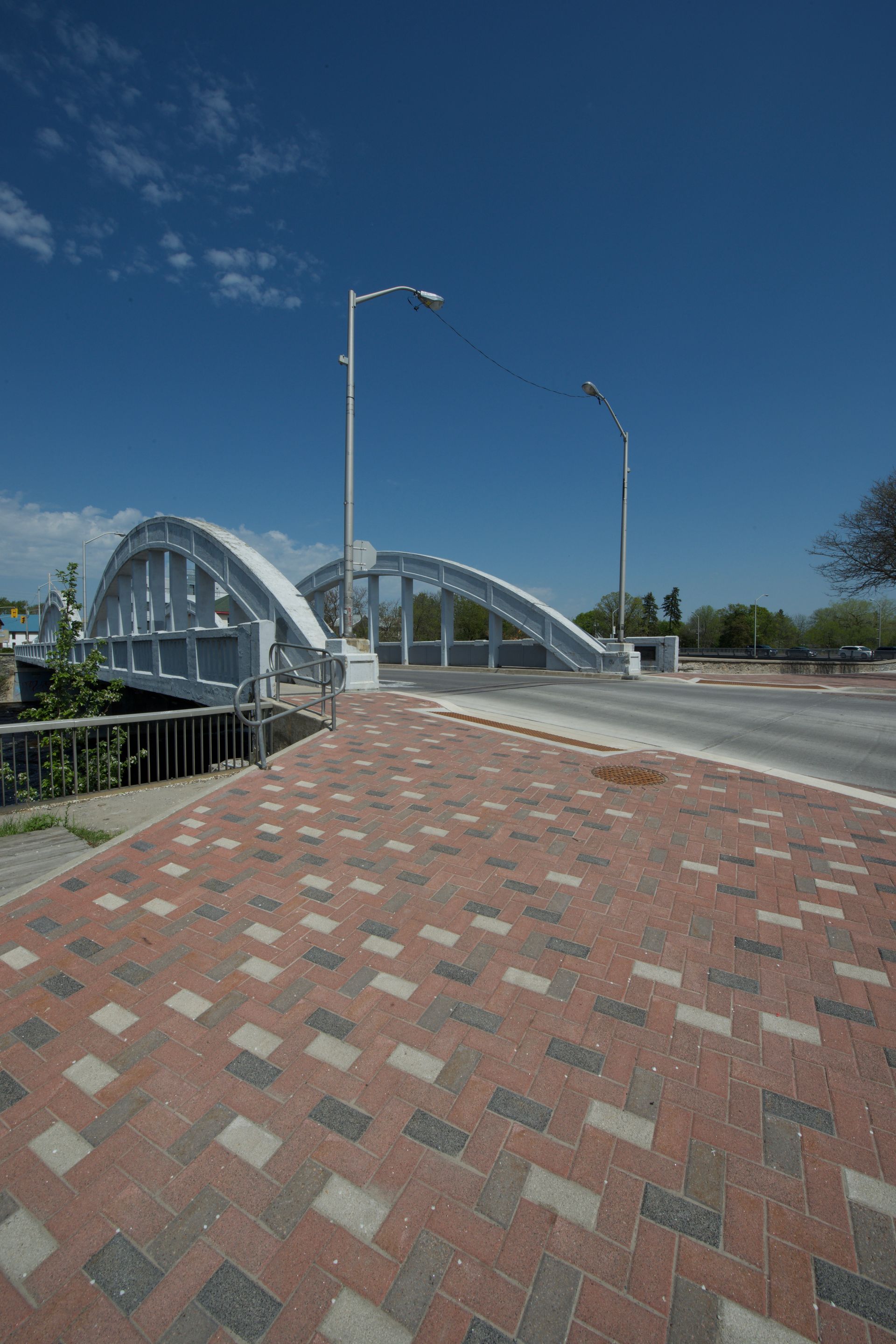 A brick walkway leading to a bridge on a sunny day