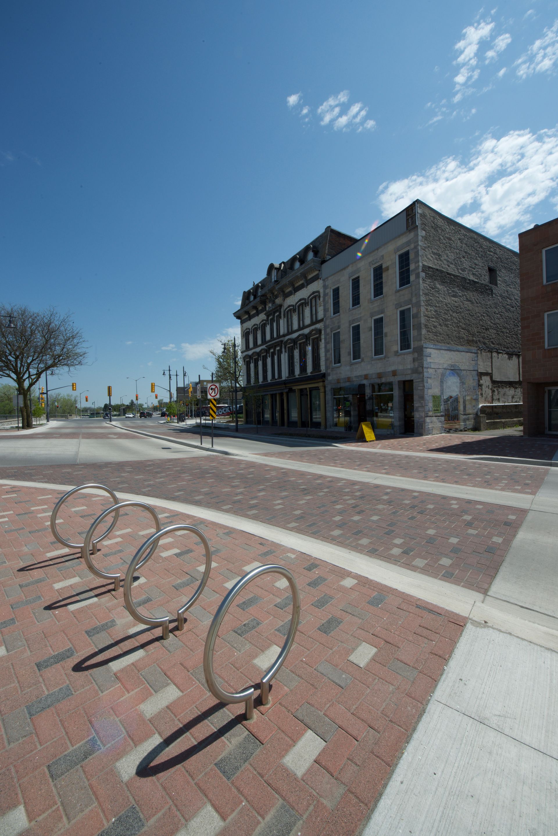 A row of bicycles are parked on the sidewalk in front of a building.