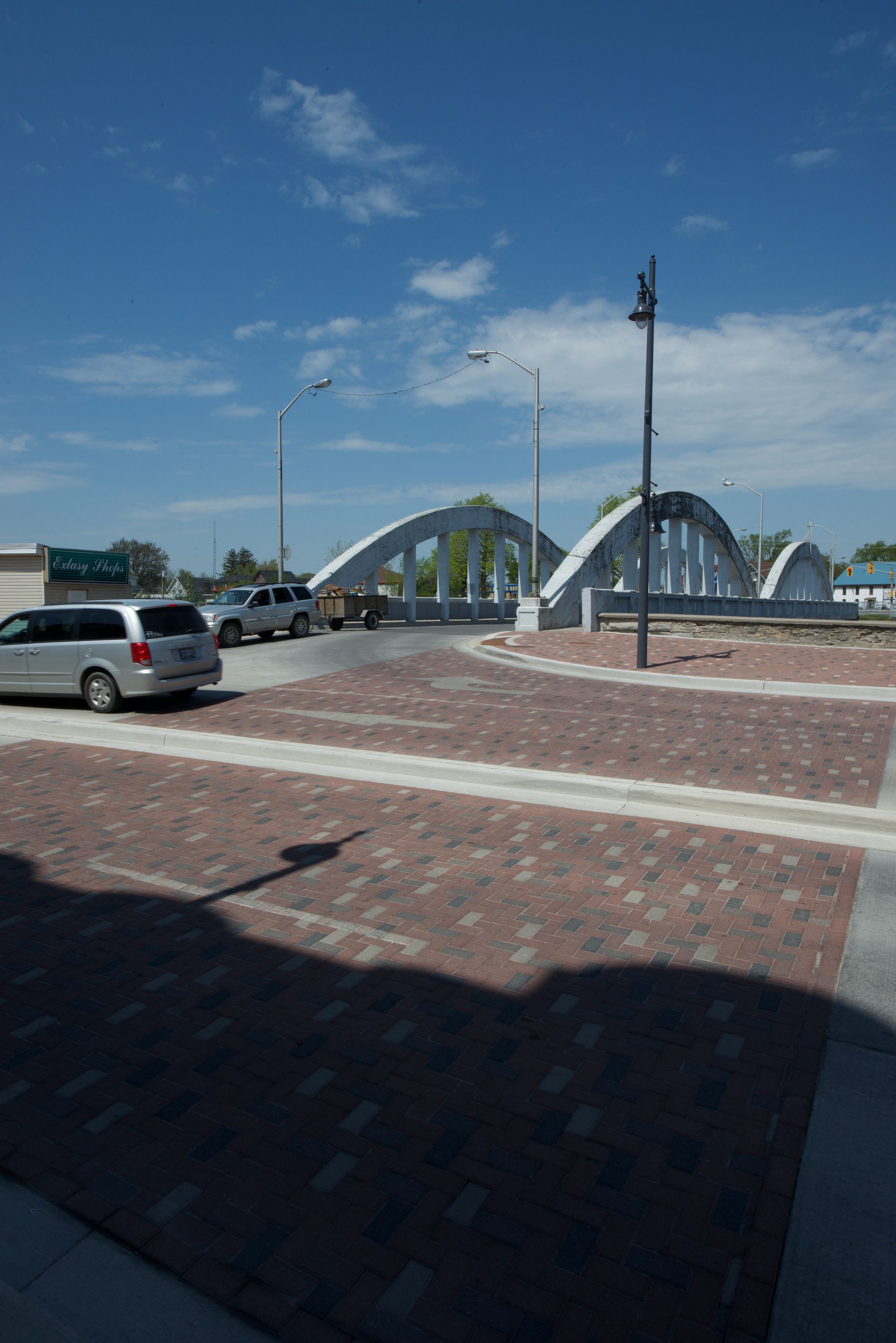 A van is parked on the side of the road in front of a bridge
