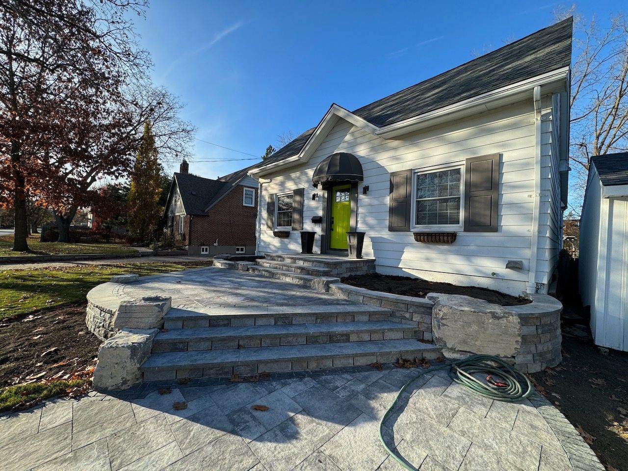A white house with a green door and steps in front of it.