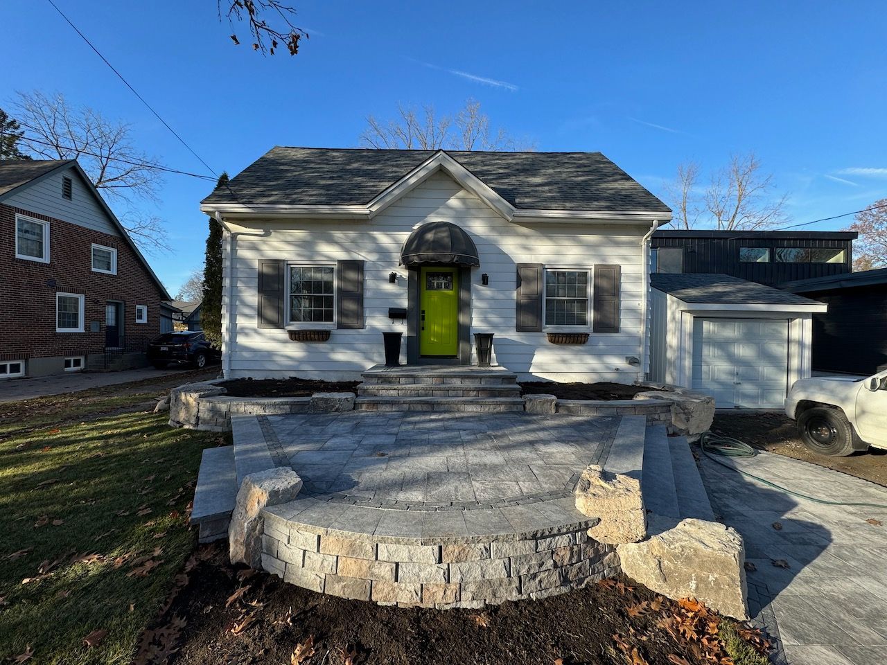 A white house with a green door and steps in front of it.