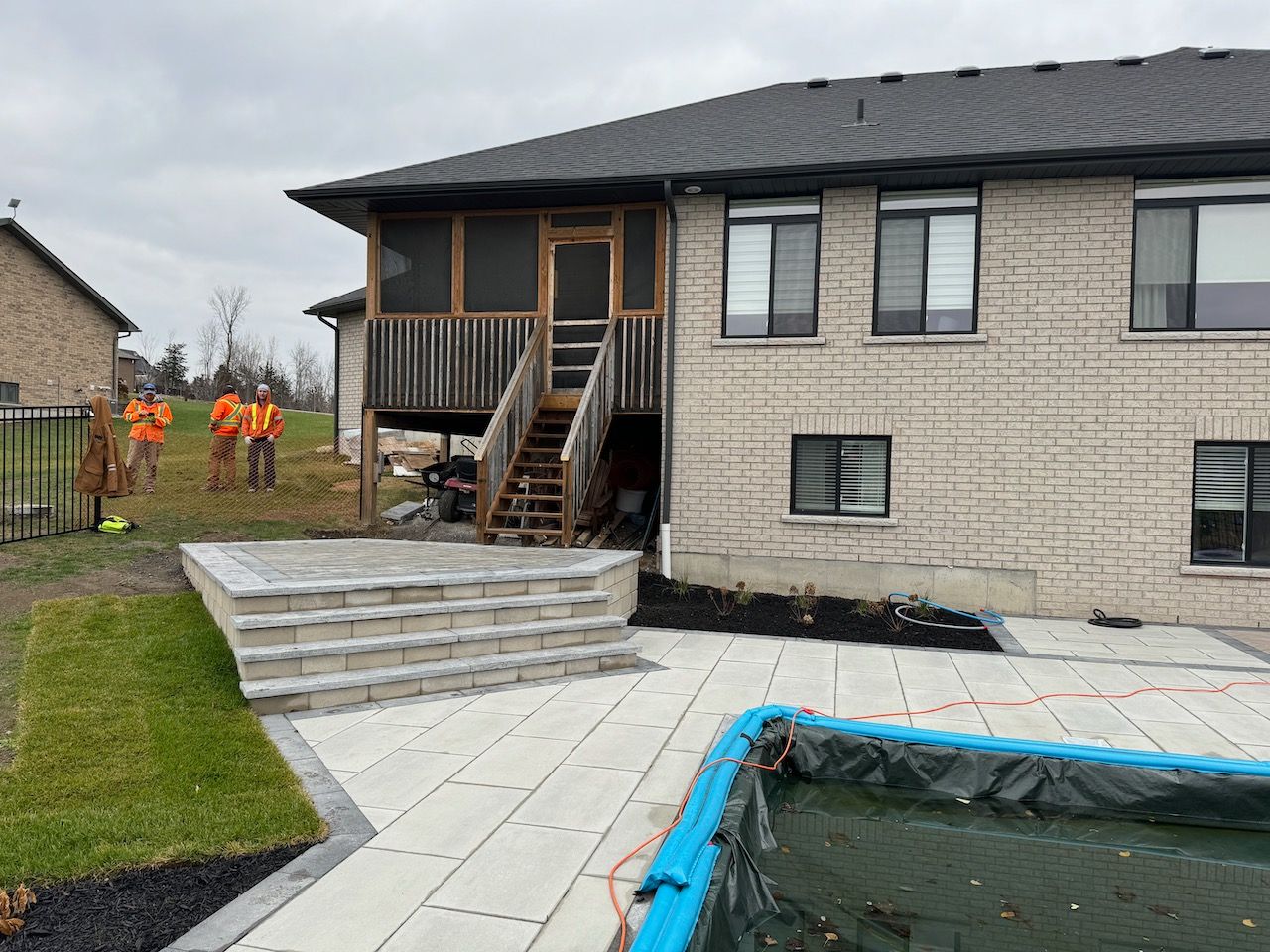 A house with a screened in porch and a pool in front of it.