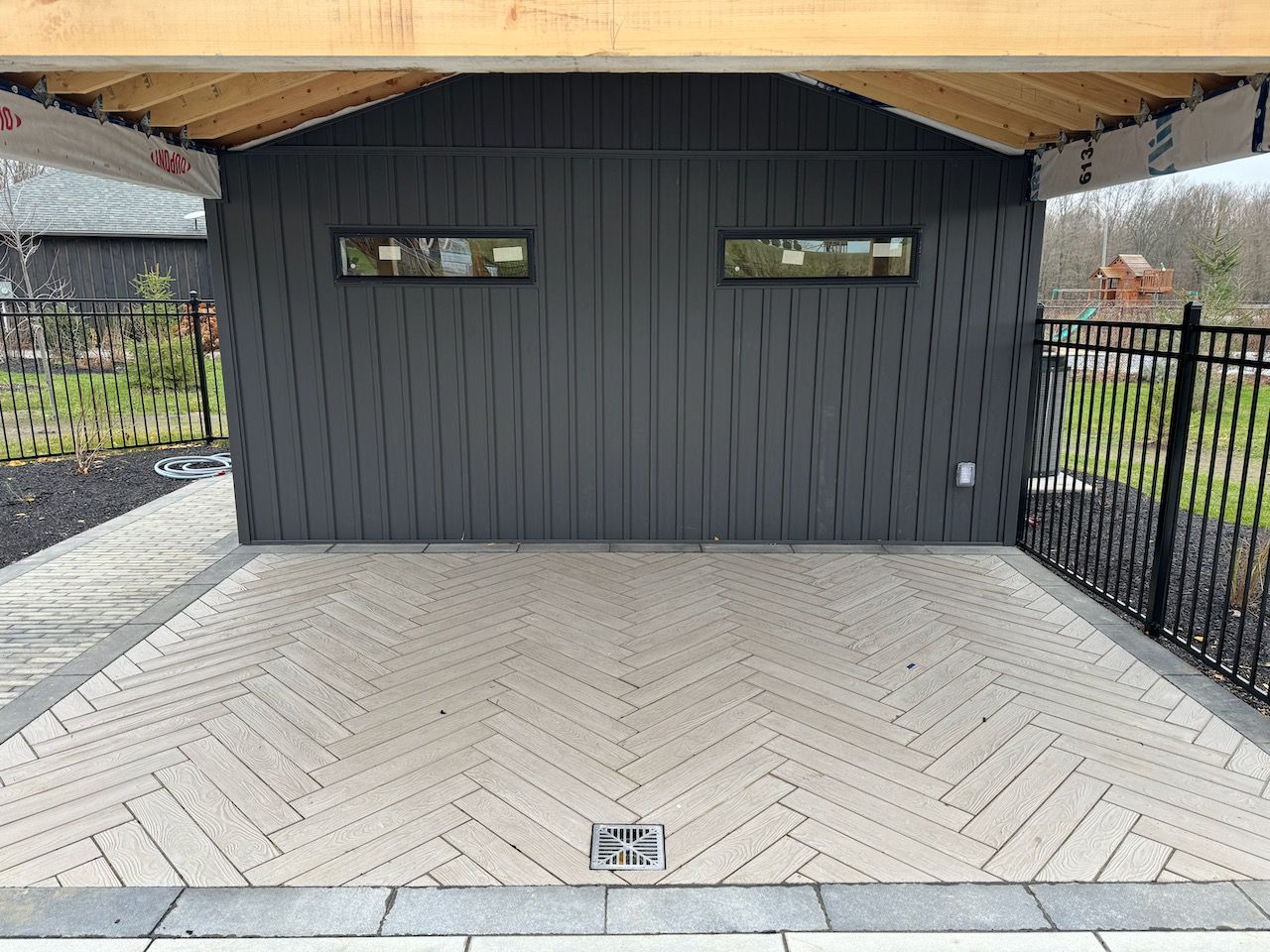A garage with a wooden roof and a herringbone pattern on the floor.