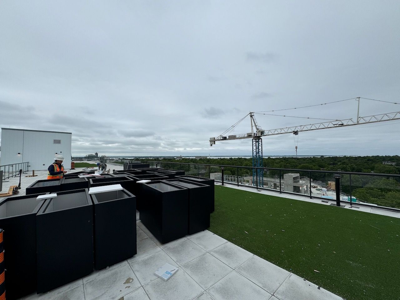 A rooftop with a lot of boxes and a crane in the background