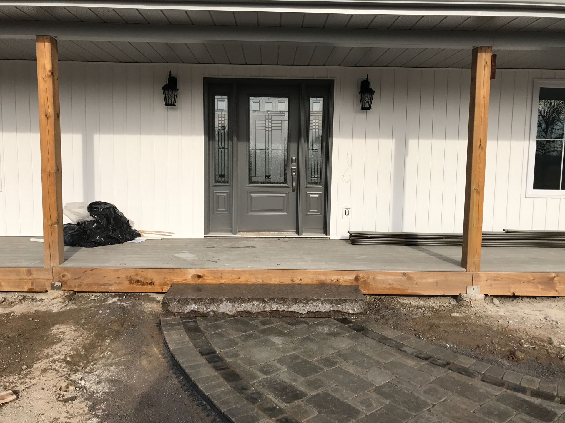 A white house with a gray door and a wooden porch