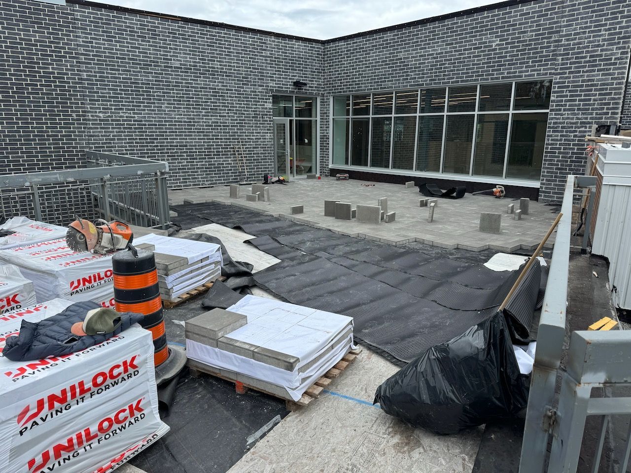 A building under construction with a lot of bricks on the ground.