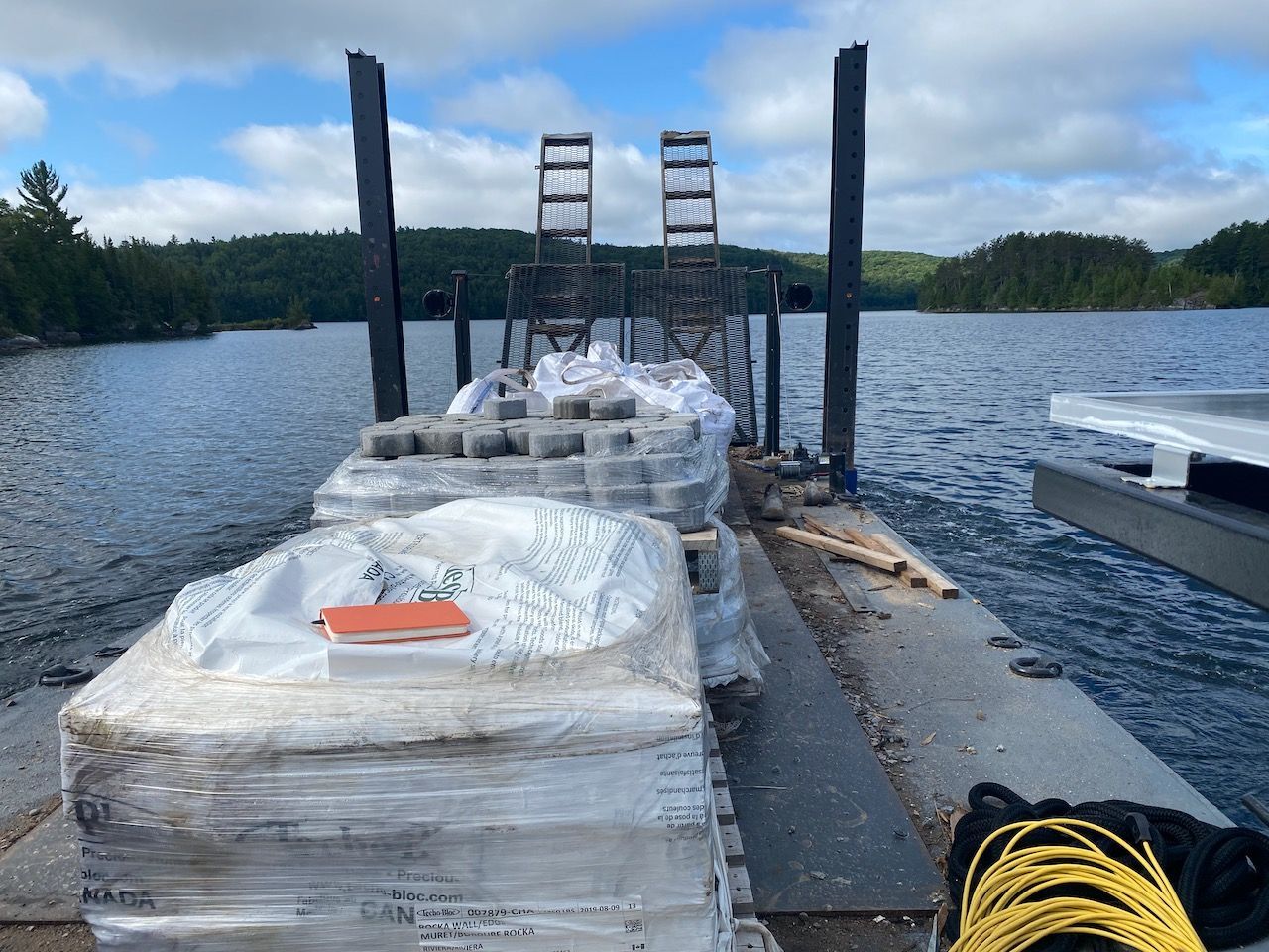 A dock with a bunch of boxes on it and a lake in the background
