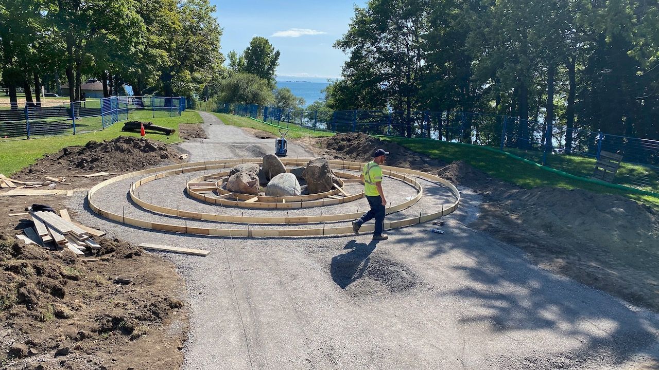 A man is walking down a dirt road in a park.