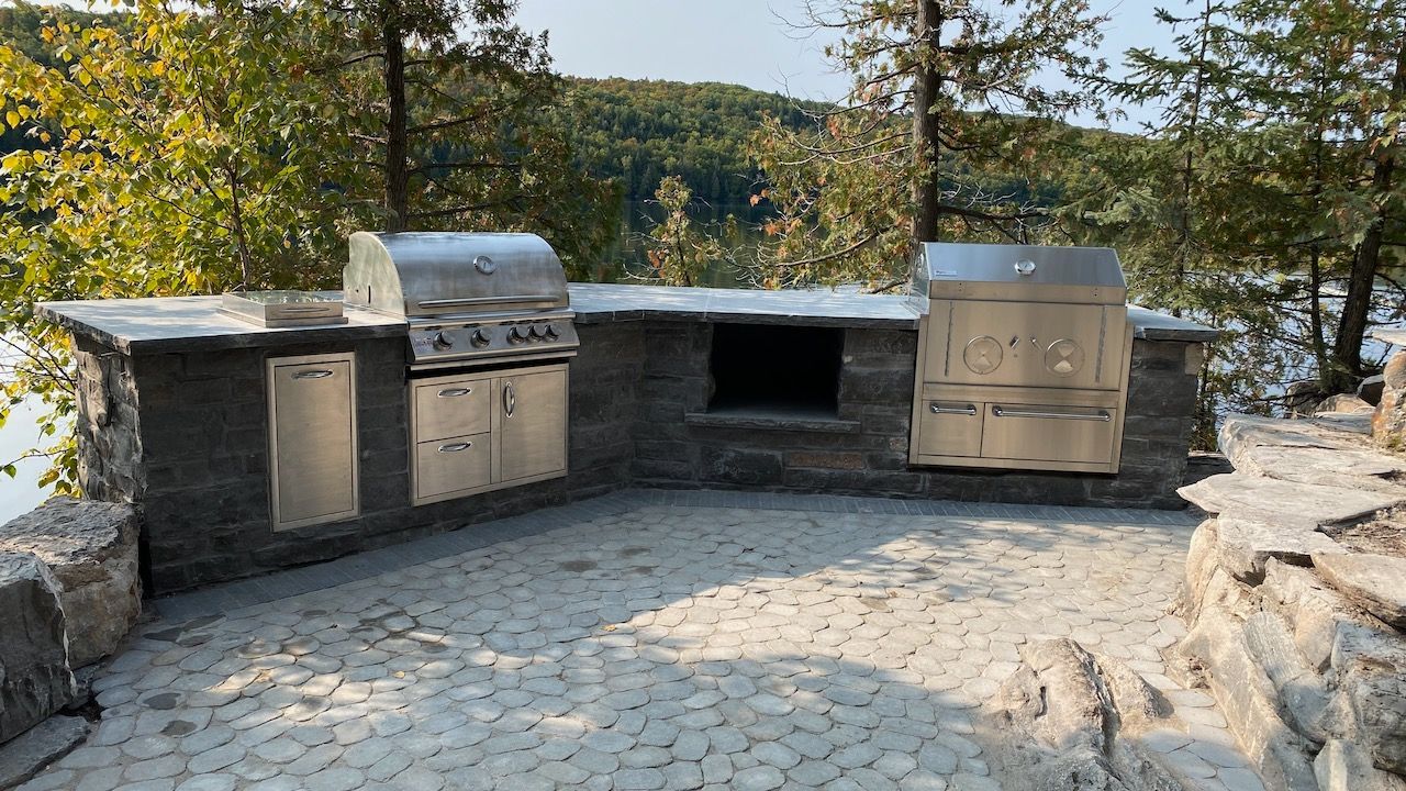 There is a large outdoor kitchen with a grill and stove.