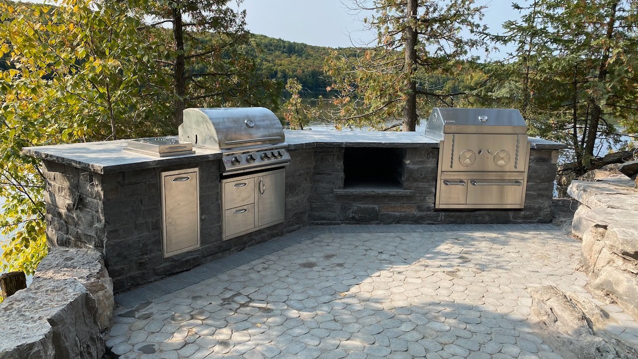 There is a large outdoor kitchen with a grill and a sink.