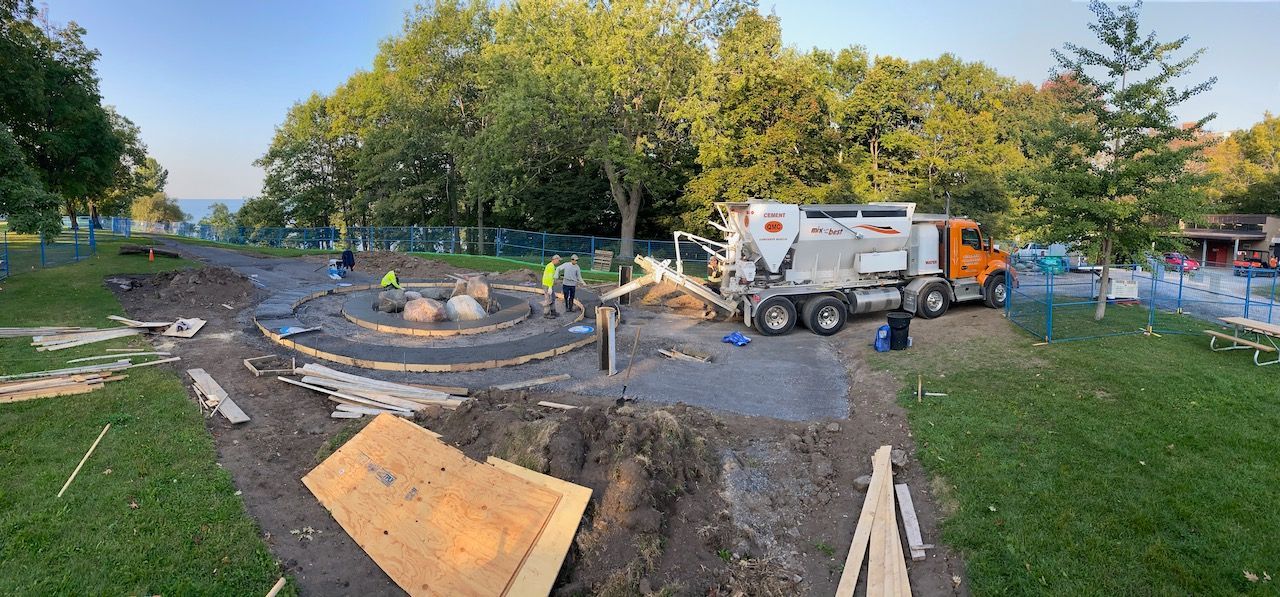A construction truck is driving down a dirt road in a park.