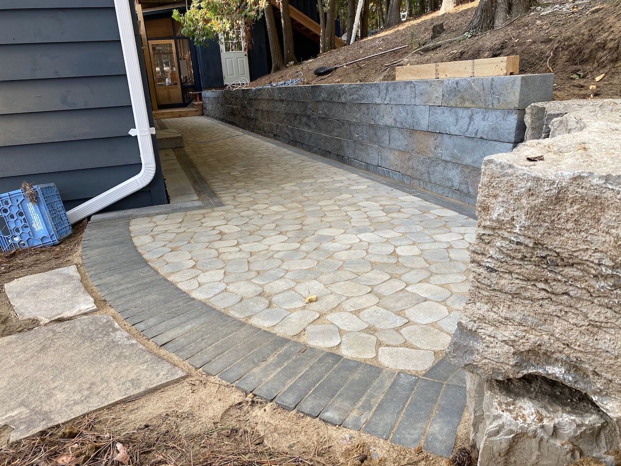 A stone walkway leading to a house on a hill.