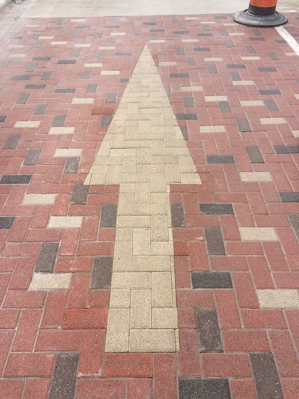 A brick walkway with an arrow pointing to the right