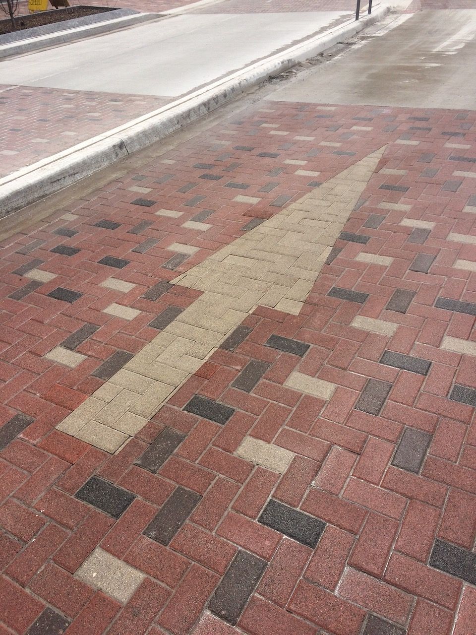 A brick sidewalk with an arrow pointing to the right.