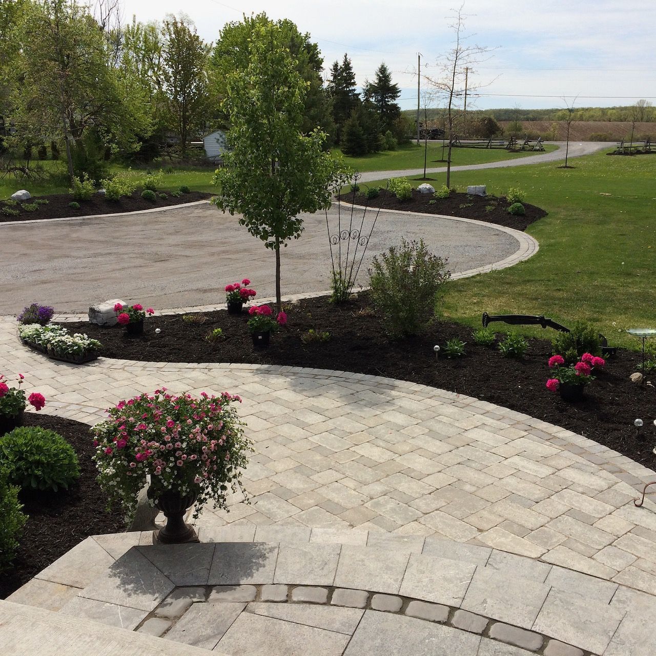 A brick walkway leading to a lush green field