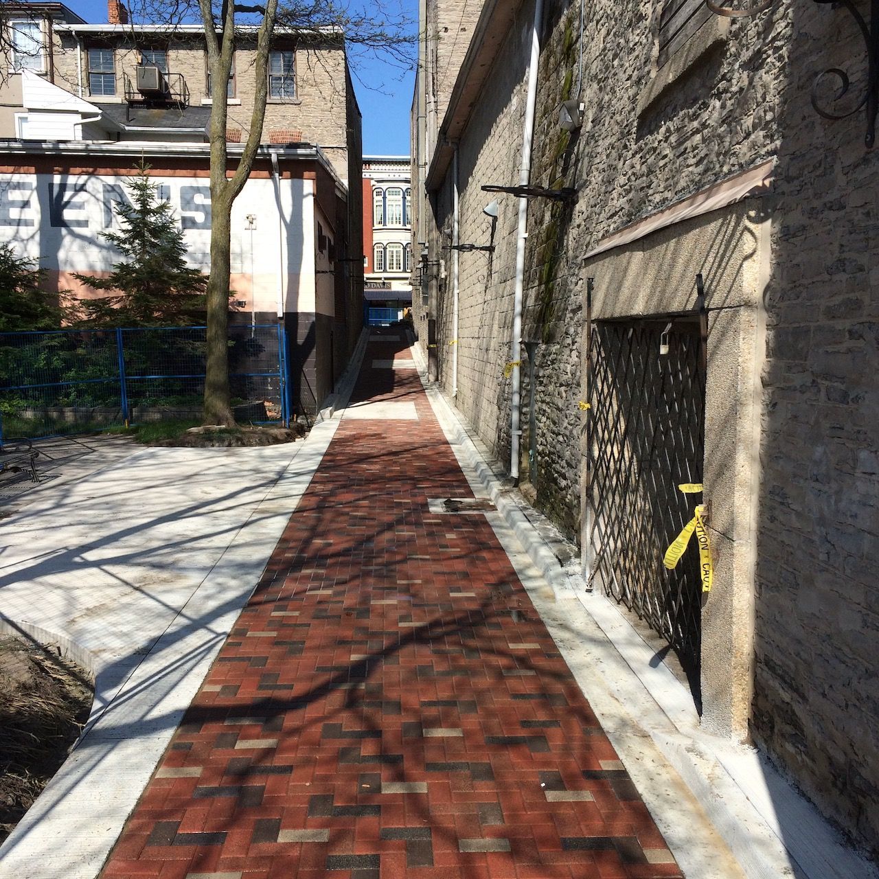 A brick walkway leading to a building with the word eyes painted on it