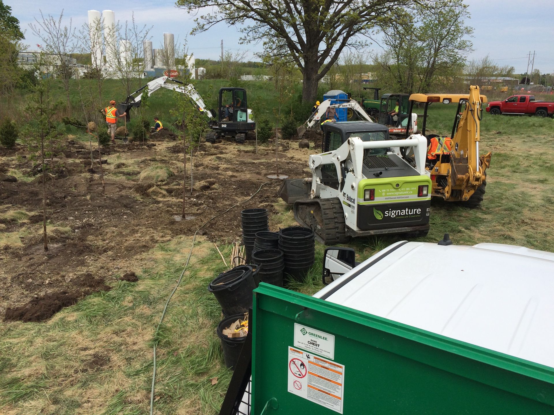 A group of construction vehicles are parked in a field.