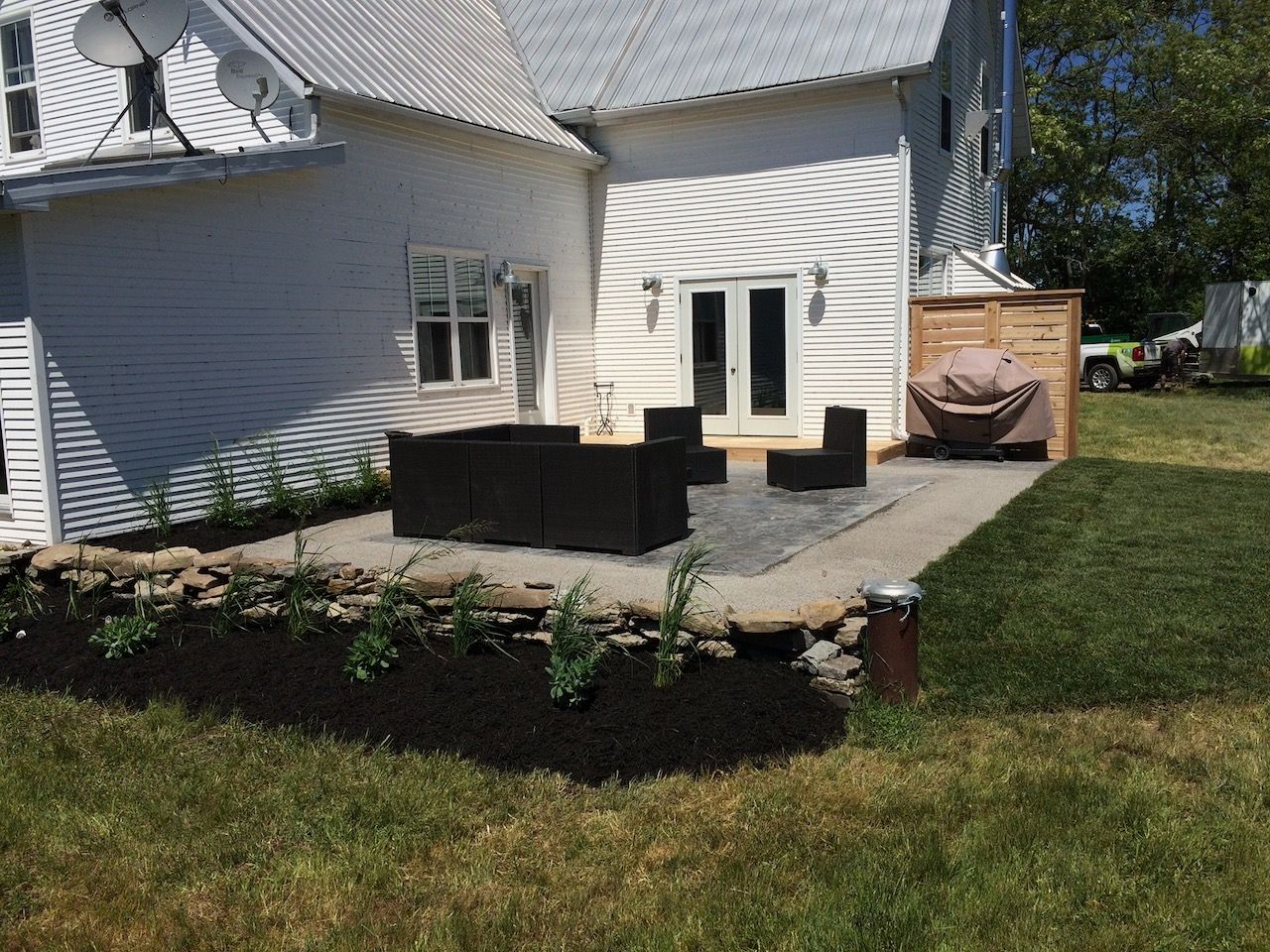 A white house with a patio area in front of it.