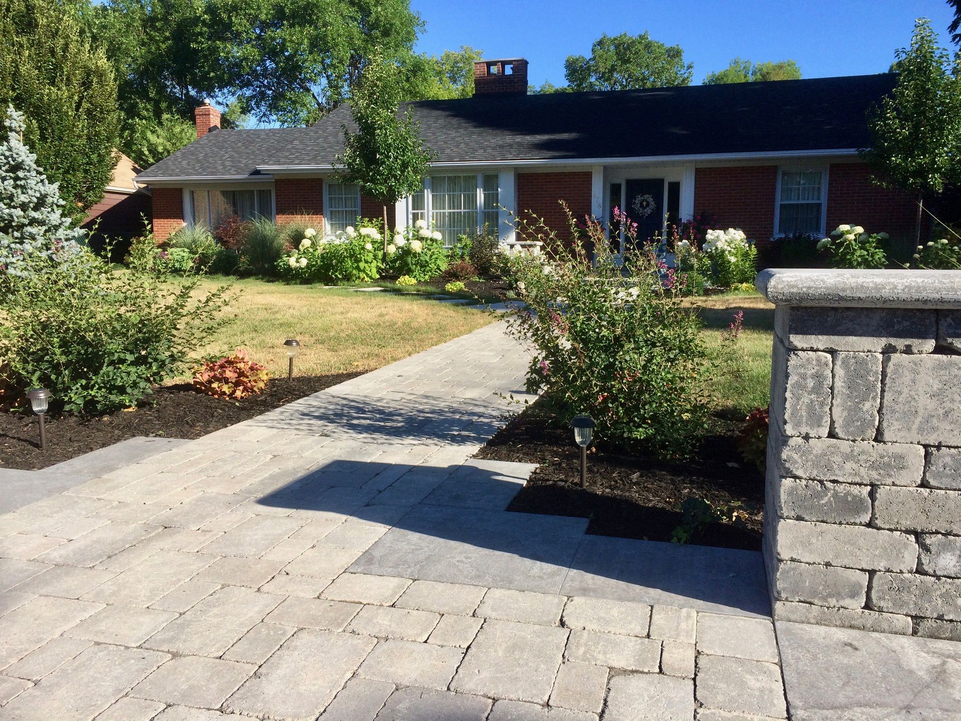 A brick house with a stone walkway leading to it