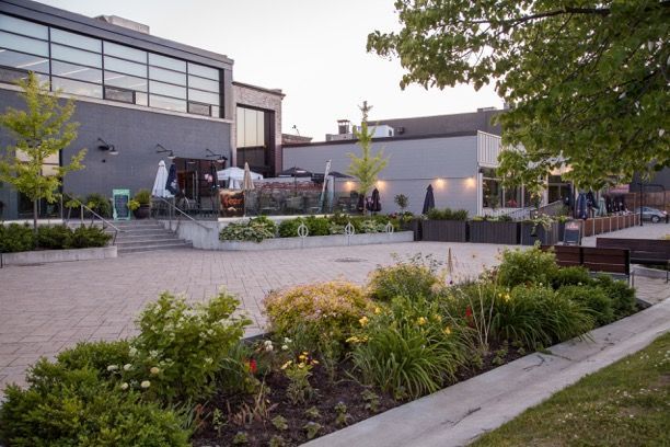 A large building with a lot of windows and a lot of plants in front of it