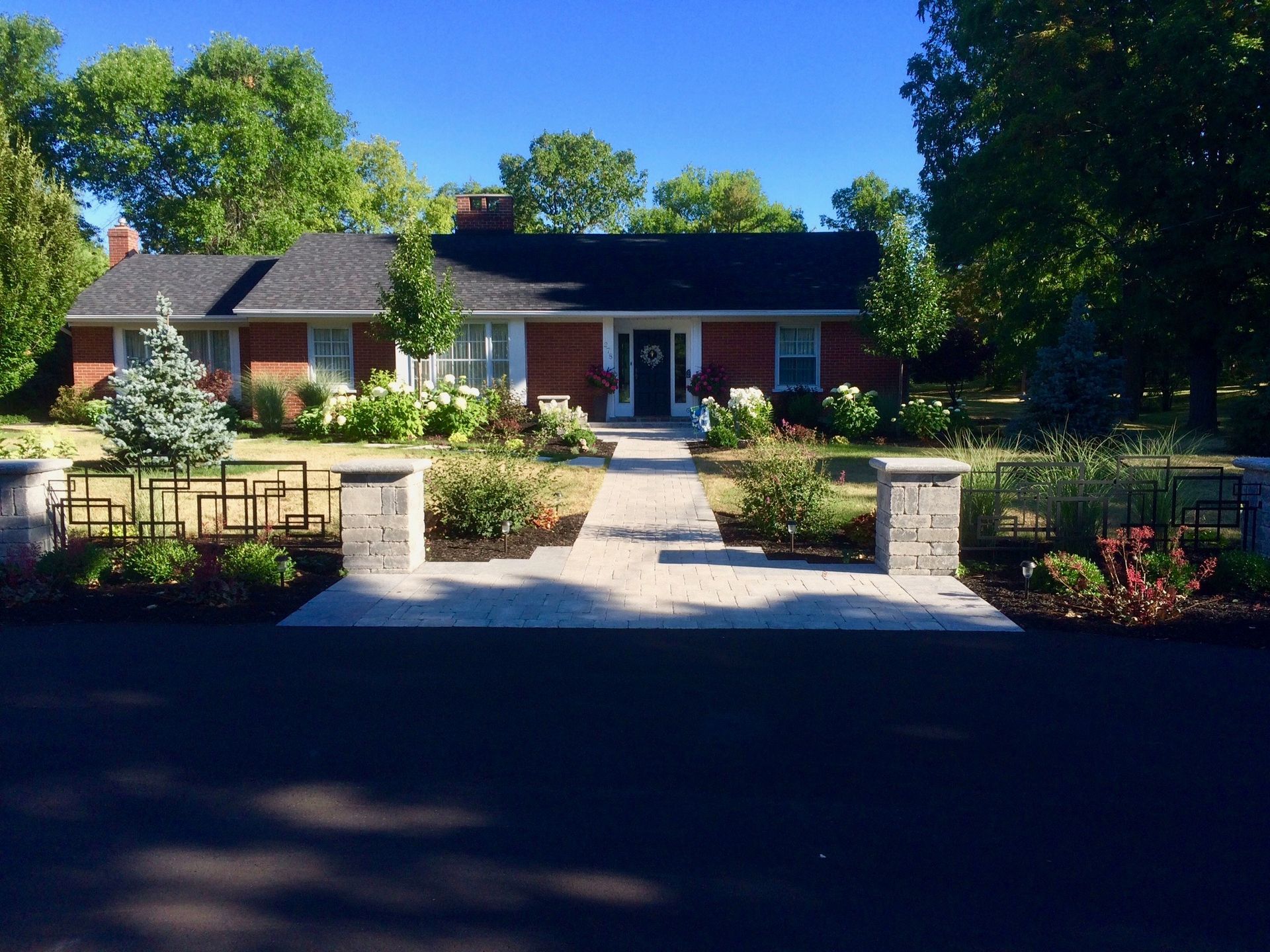 A brick house with a walkway leading to the front door