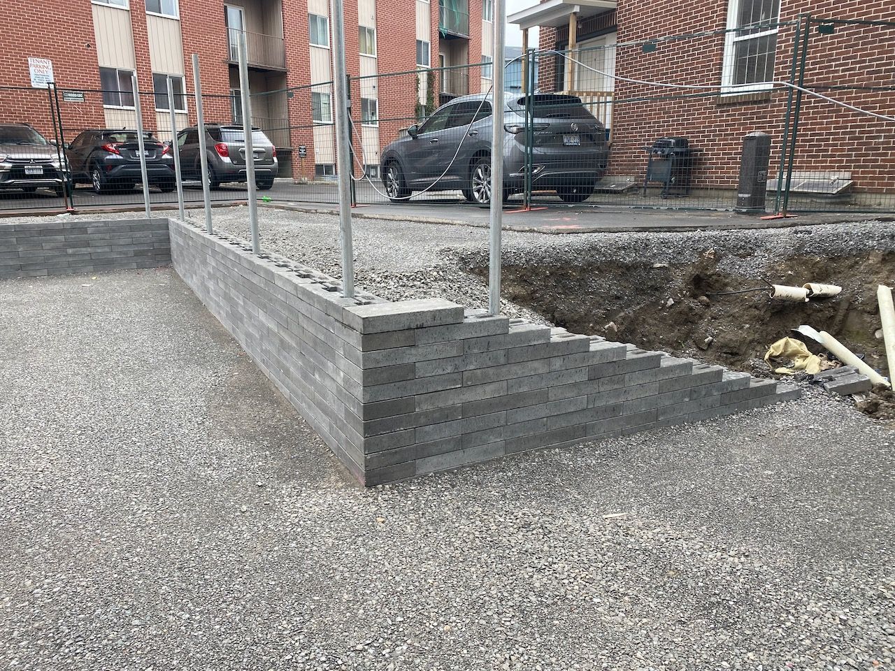 A car is parked in front of a brick building.