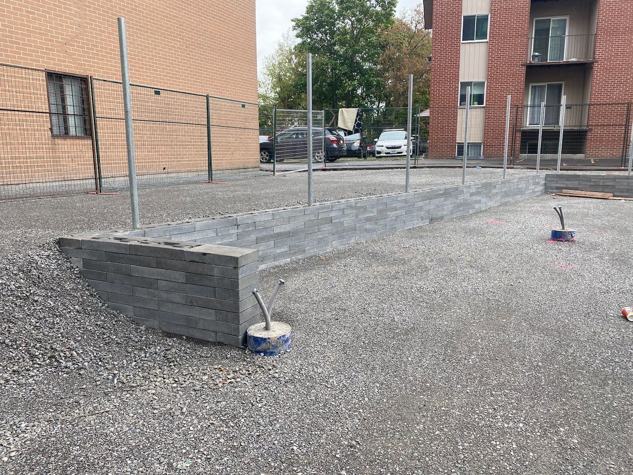 A pile of gravel is sitting in front of a brick building.