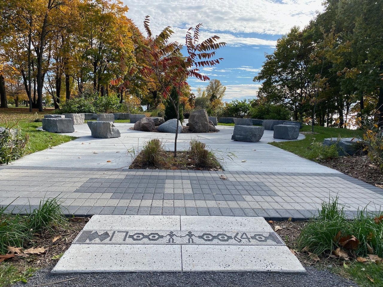 A brick walkway in a park with trees in the background