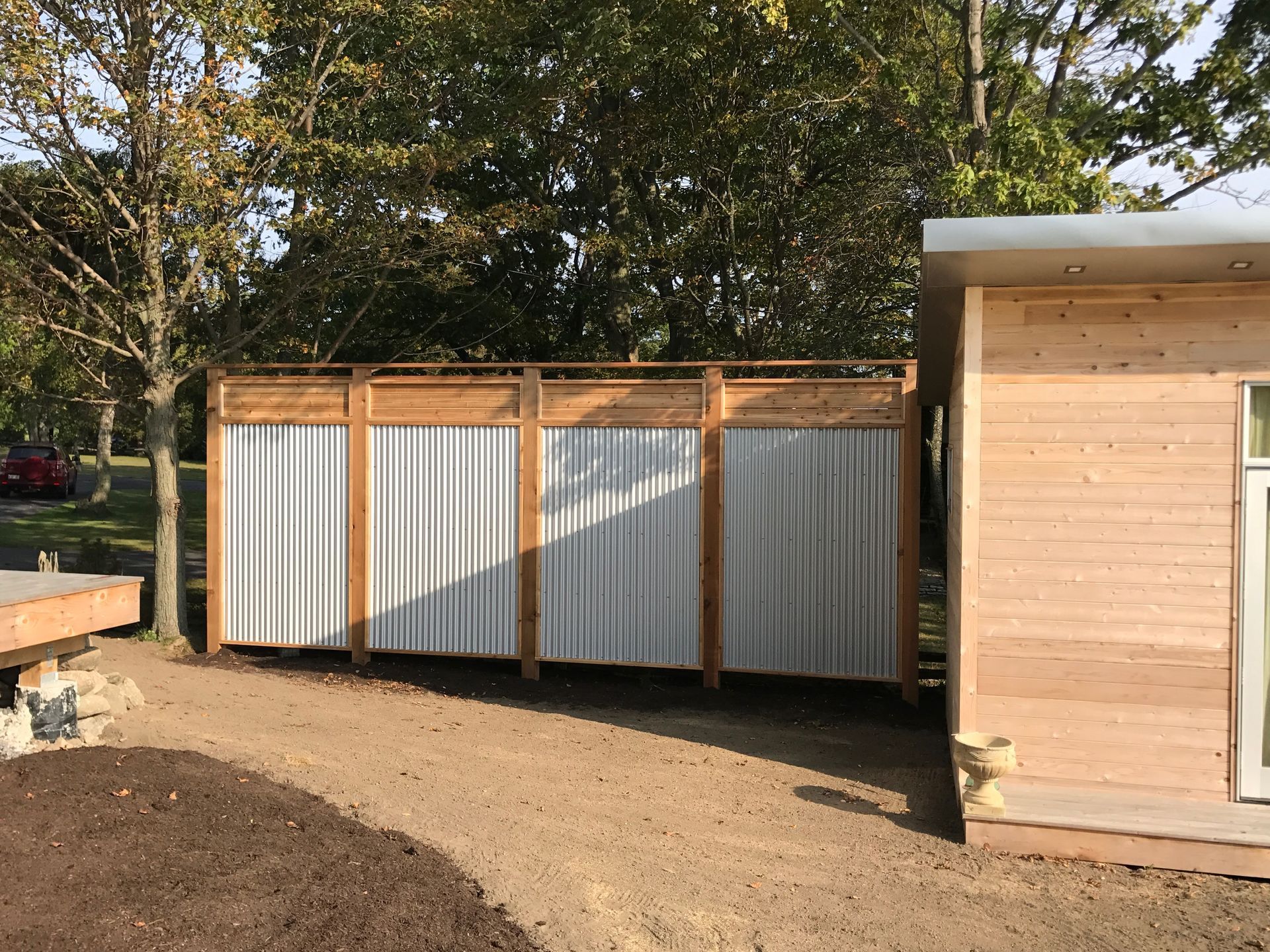 A wooden shed with a metal fence in front of it.