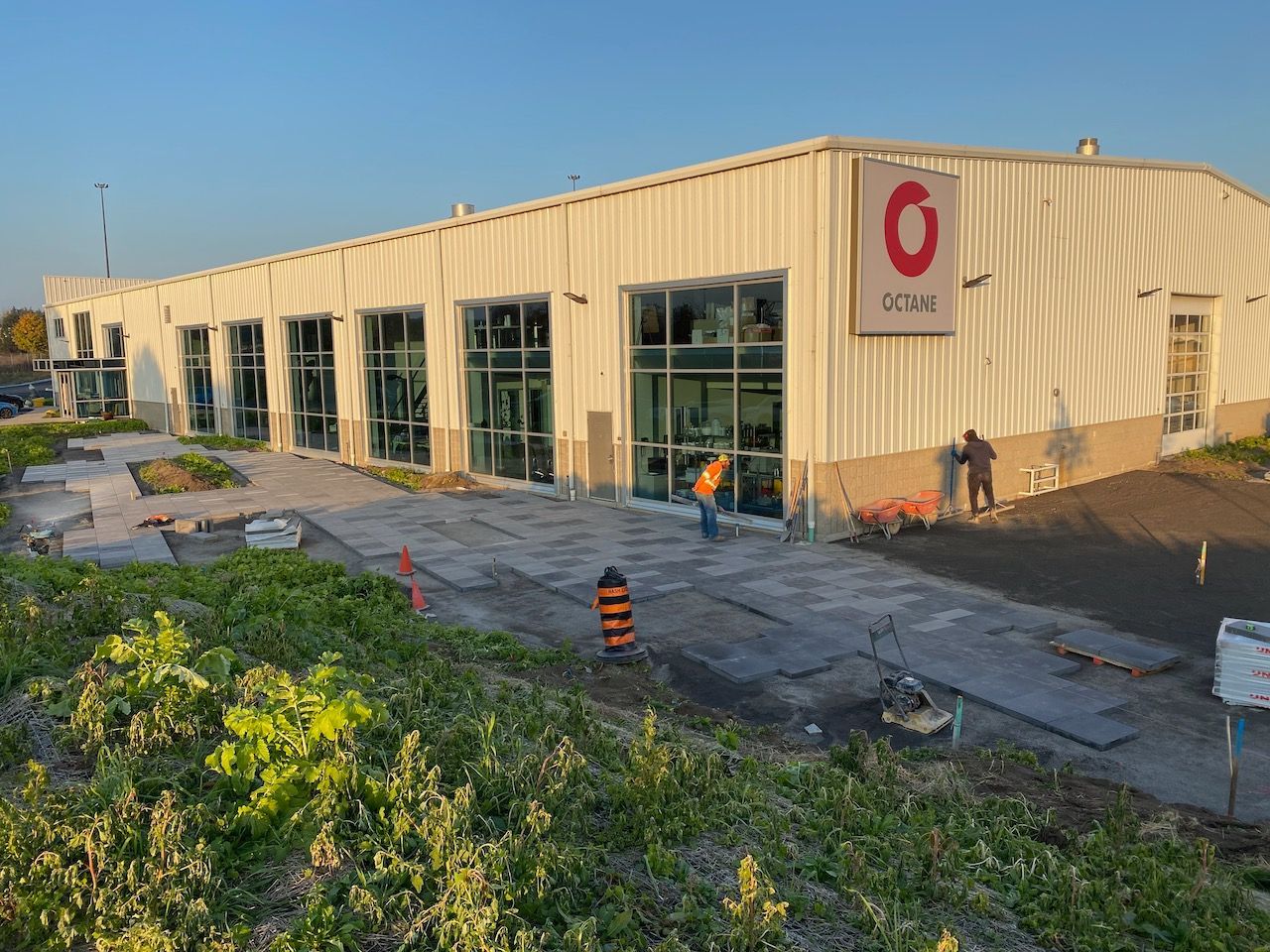 A large white building with a red o on it is being built.