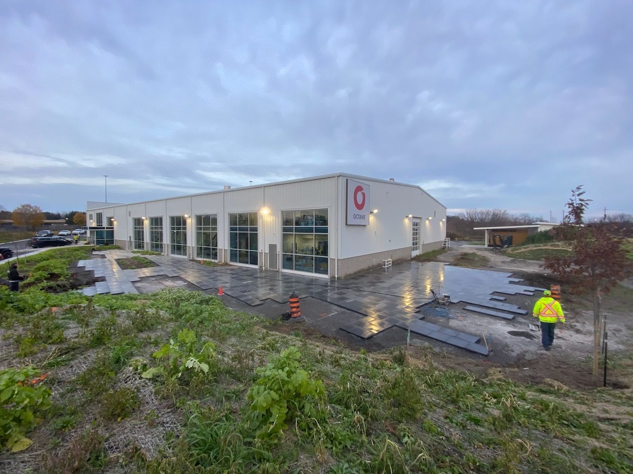 A large white building is being built in the middle of a field.