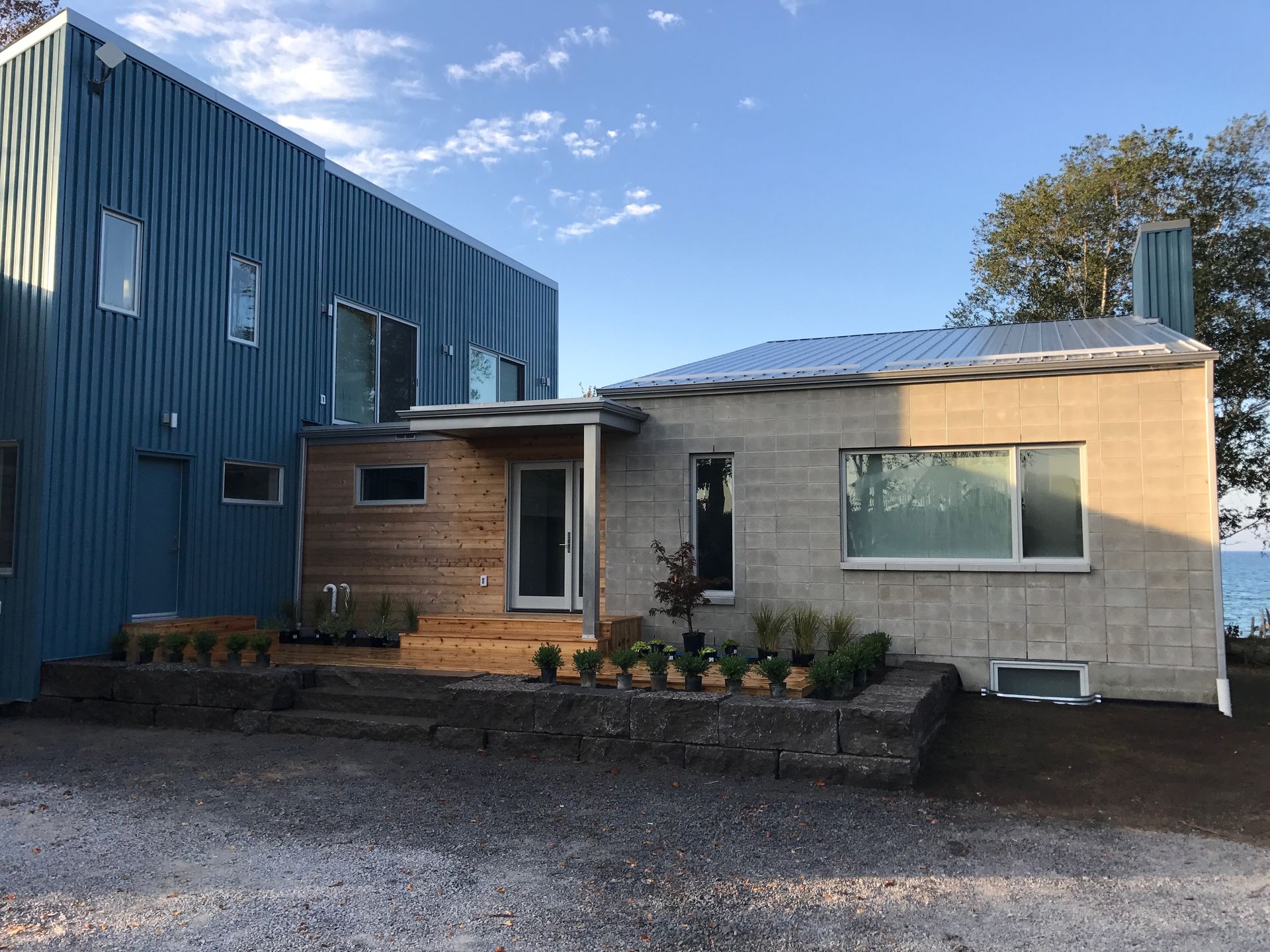 A house with a blue roof and a brick building next to it