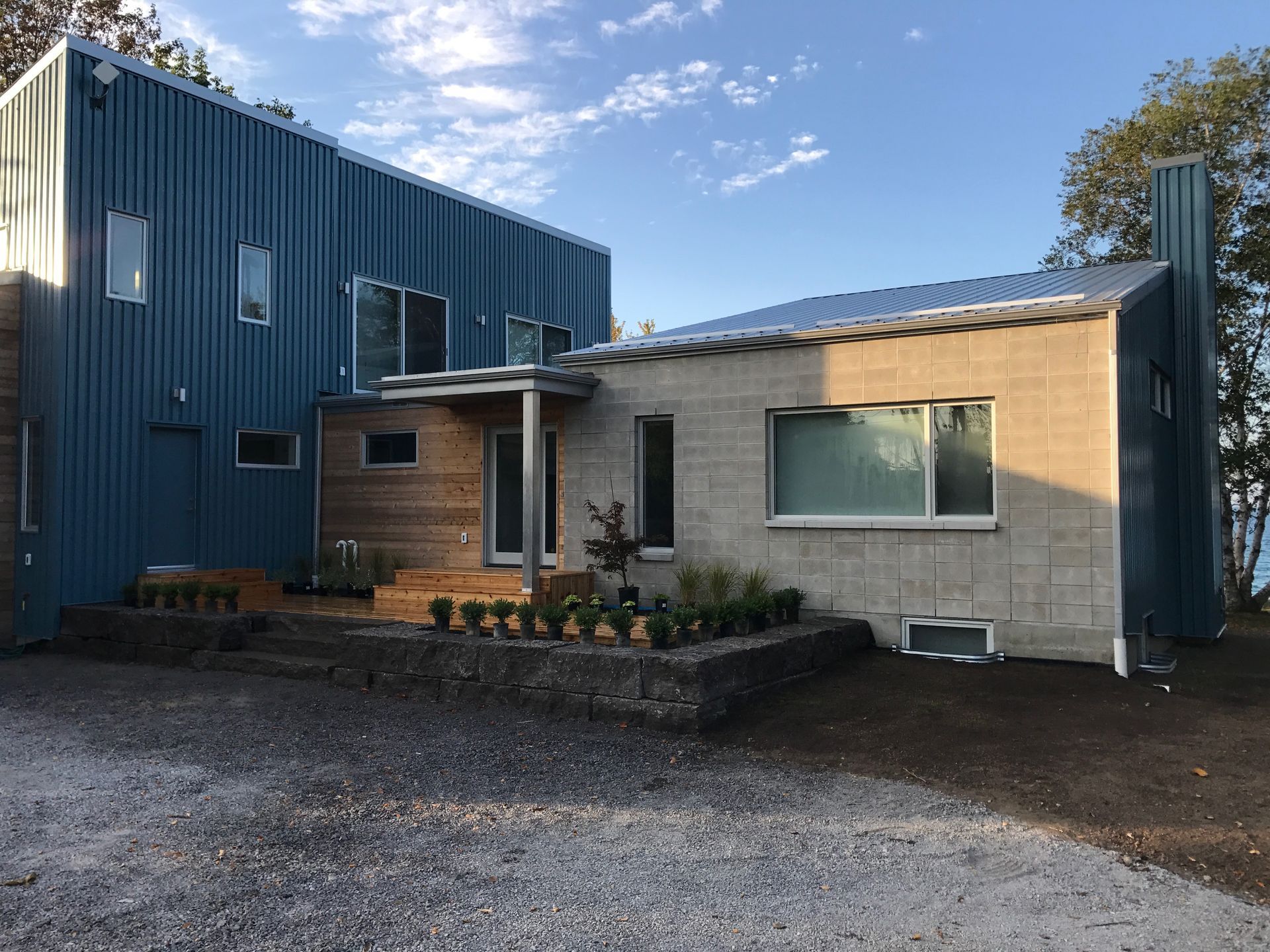 A blue and white house with a lot of windows and a driveway.
