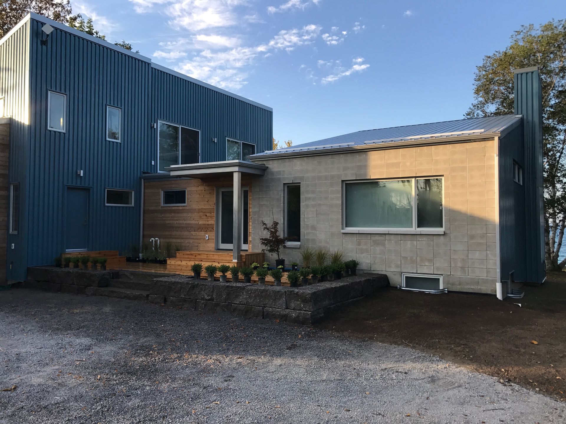 A large house with a lot of windows and a lot of gravel in front of it.