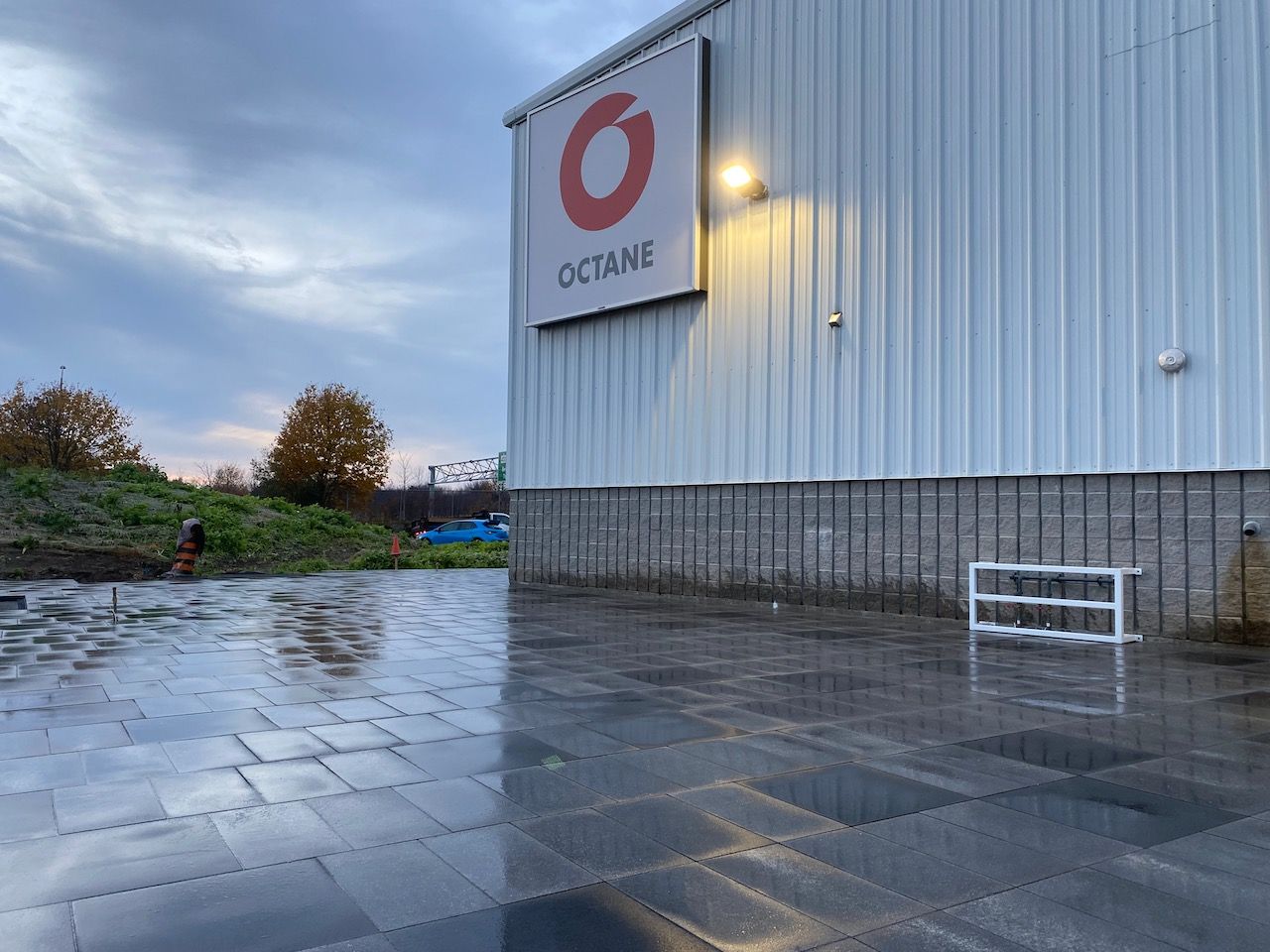 A large white building with a red octane sign on the side of it.