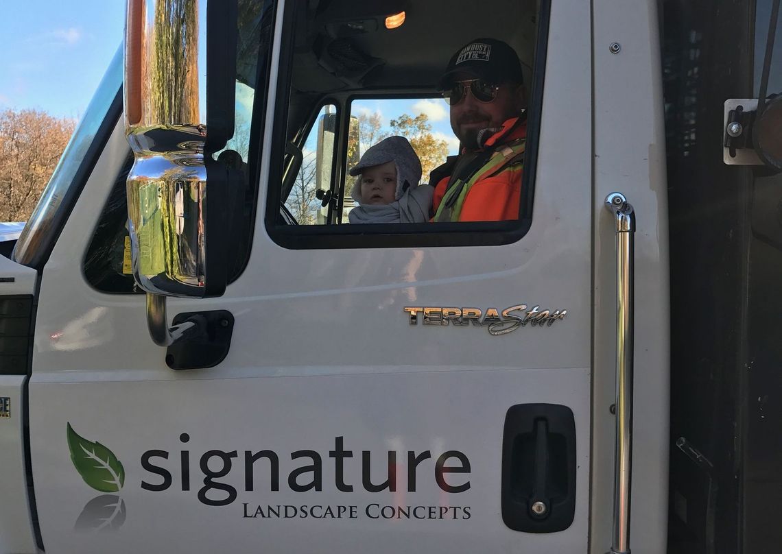 A man is driving a signature dump truck