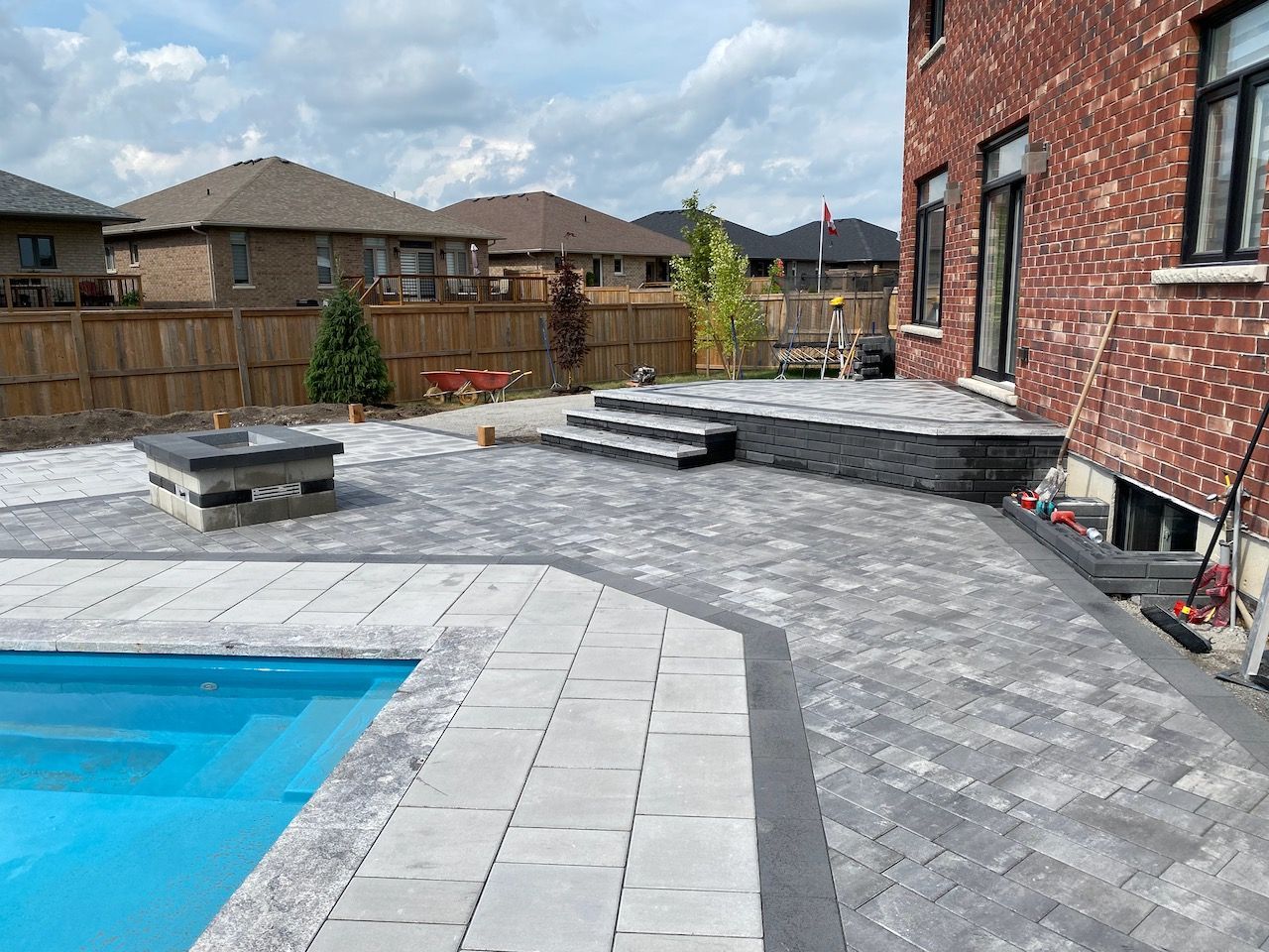 There is a swimming pool in the backyard of a house.