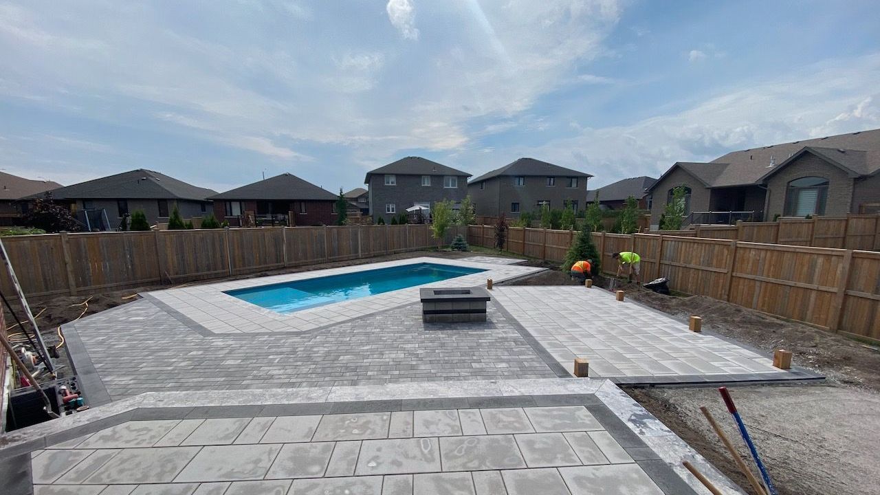 A large swimming pool is being built in the backyard of a house.