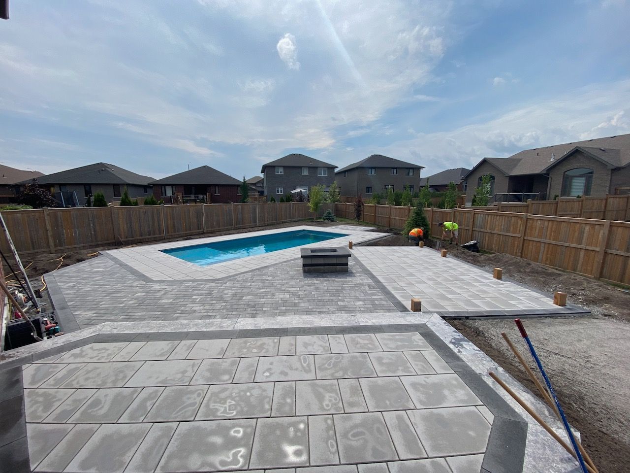 A large swimming pool is being built in the backyard of a house.