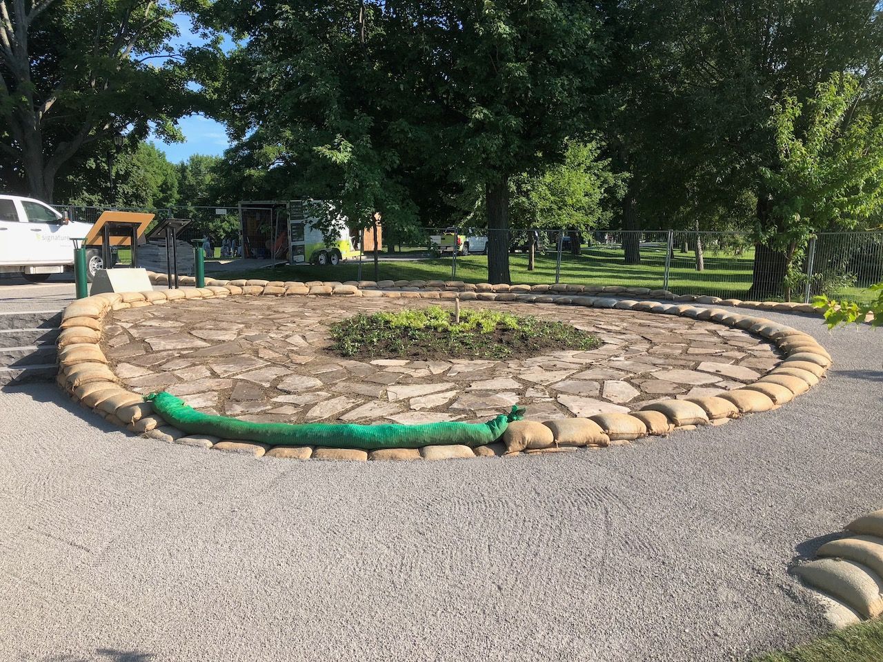 A circle of rocks with a green hose in the middle