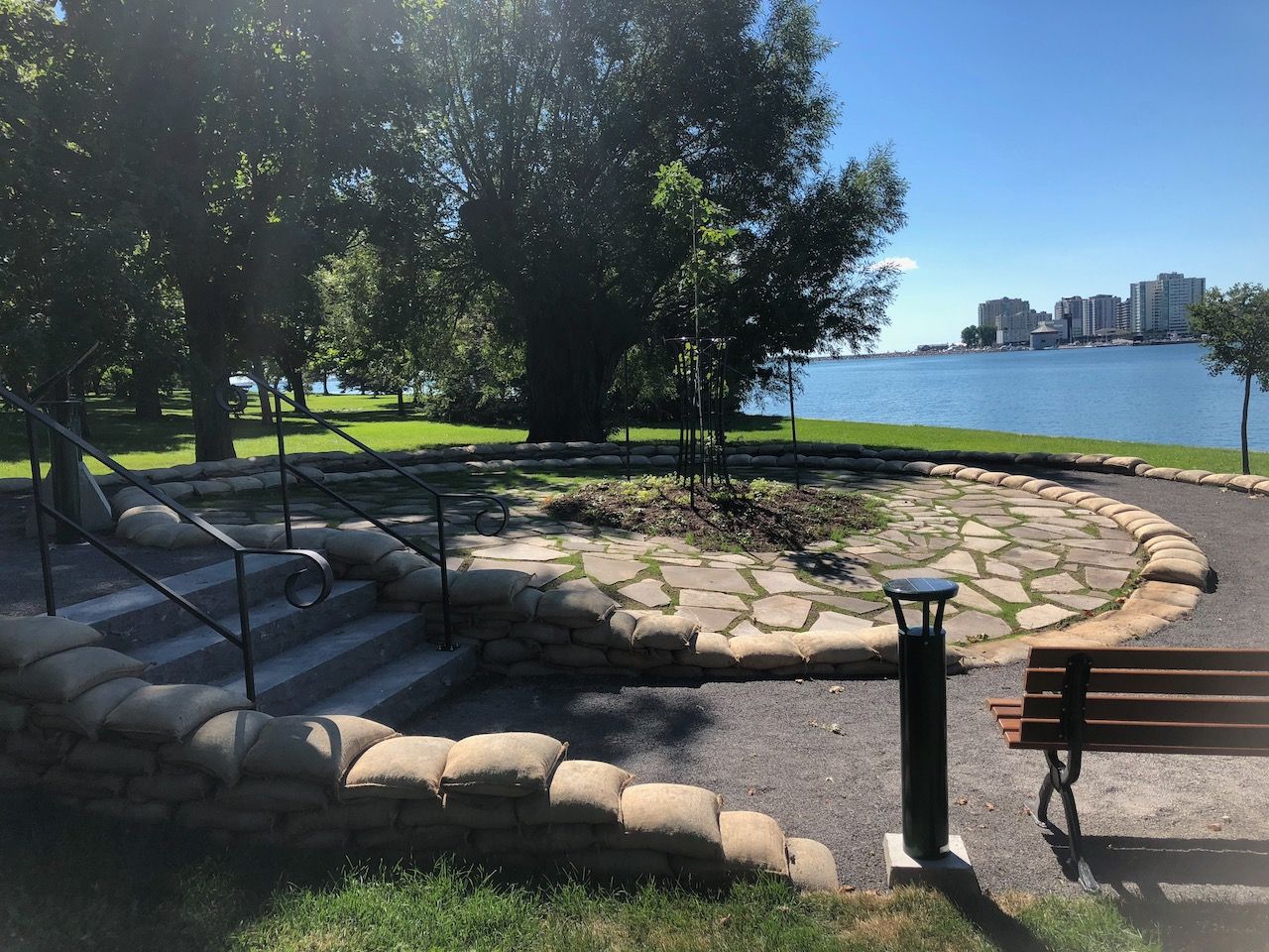 A park with a bench and stairs leading to the water