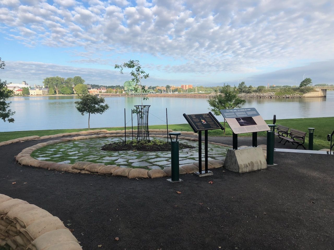 A park with a lake in the background and a sign in the foreground.