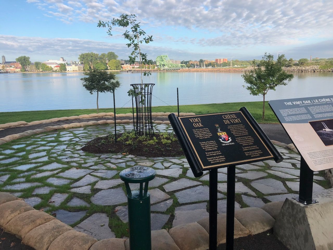 A sign in a park with a lake in the background