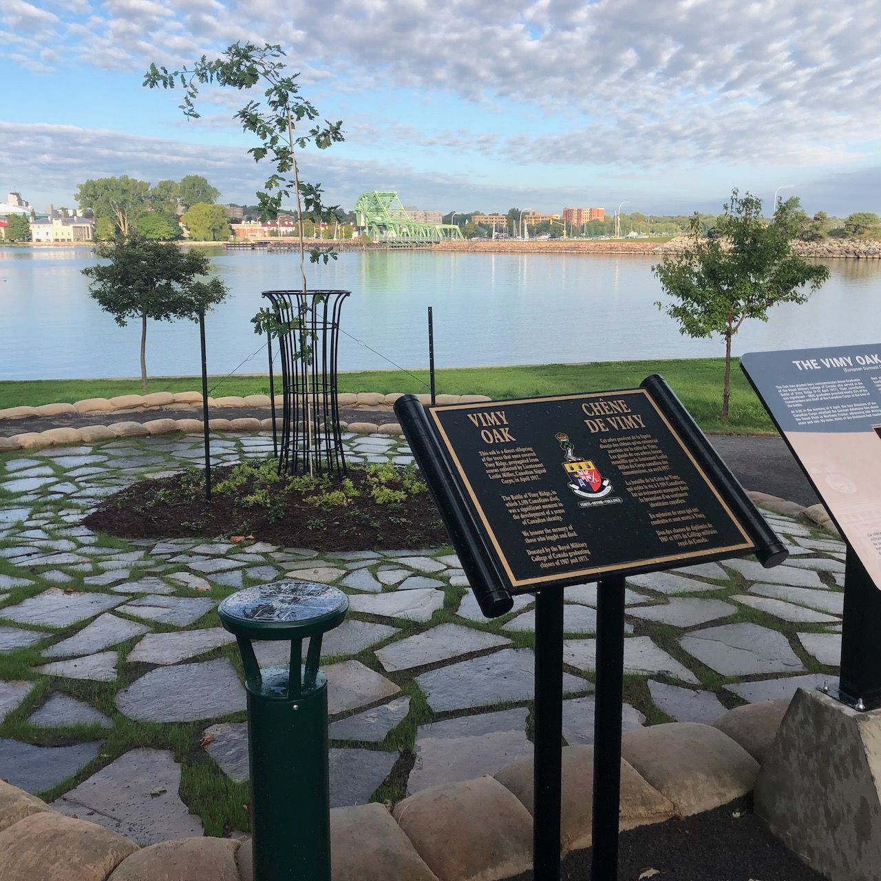 A sign in front of a lake that says ' a few trees ' on it
